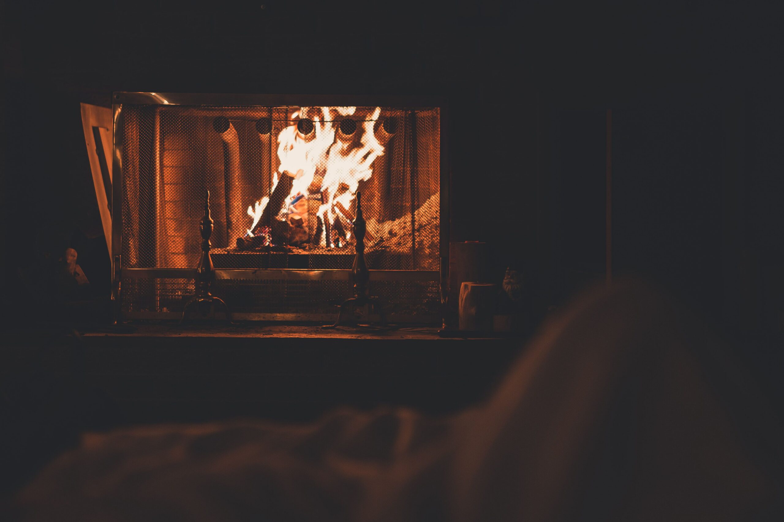 Wood fire burning inside a fireplace with visible flames and logs
