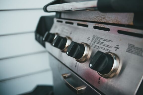 Close-up of the control knobs on a stainless steel barbecue grill