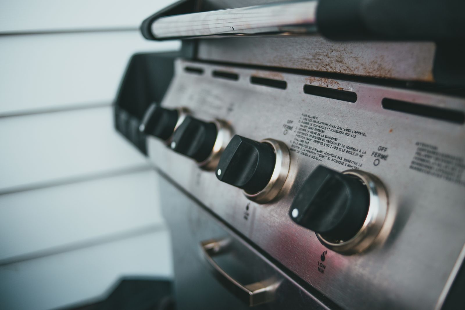 Close-up of the control knobs on a stainless steel barbecue grill
