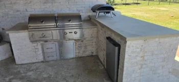 Outdoor kitchen island with built-in grill, pizza oven and refrigerator after cleaning in DFW
