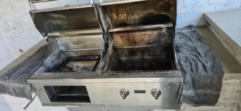 Built-in grill with heavy grease and carbon buildup before cleaning by Texas Grill Clean